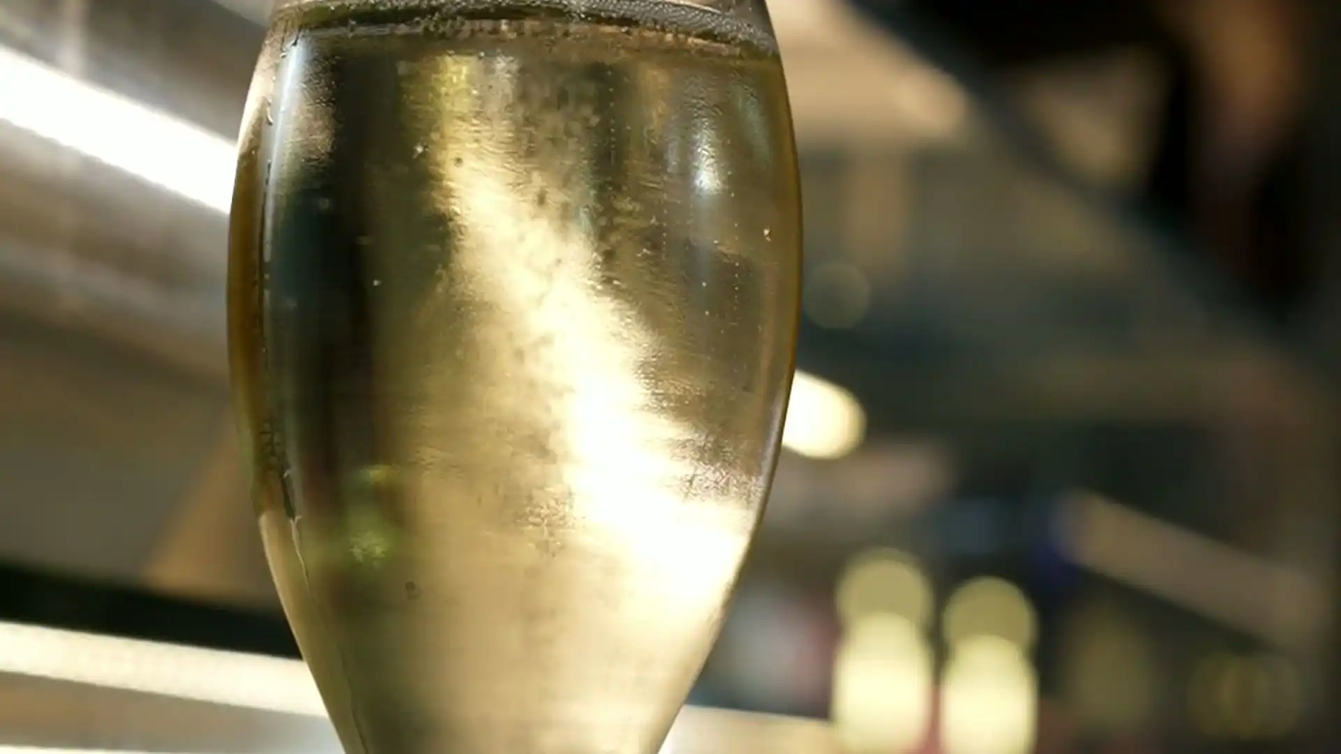Fine bubbles rising in a flute of pale sparkling wine, then green chardonnay bunches on the vine