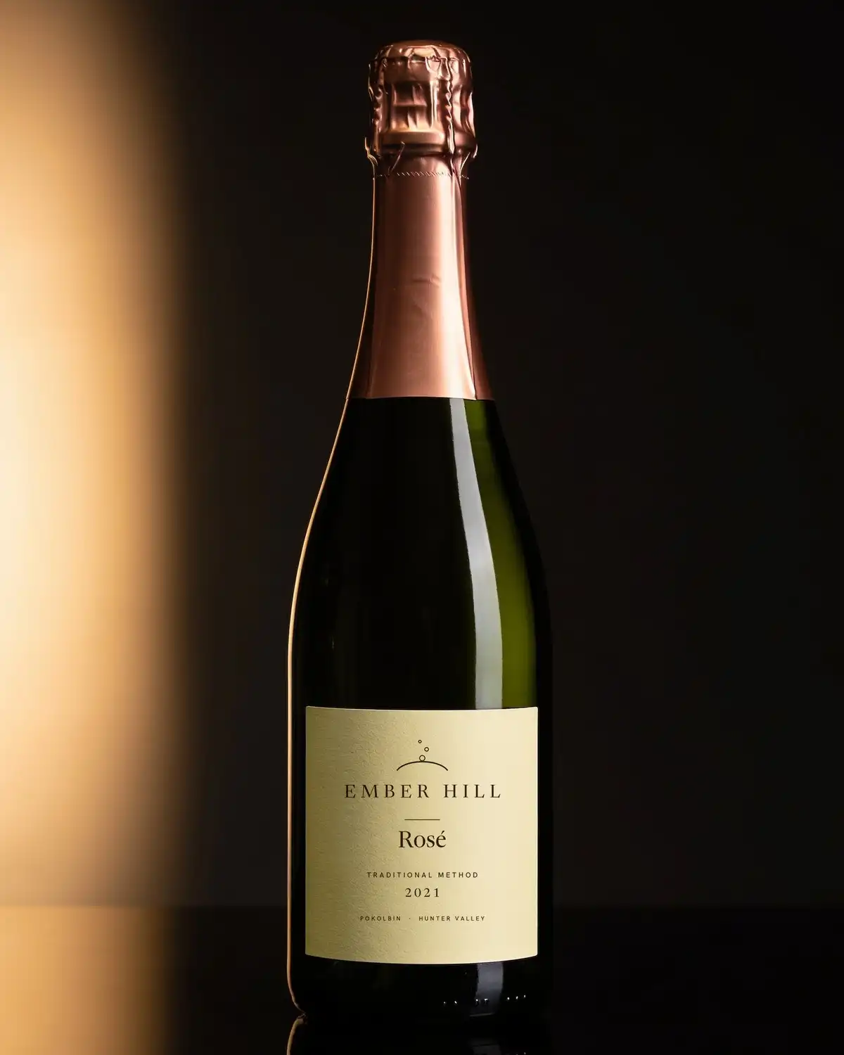 A bottle of Ember Hill Rosé 2021, cream label, on a dark table